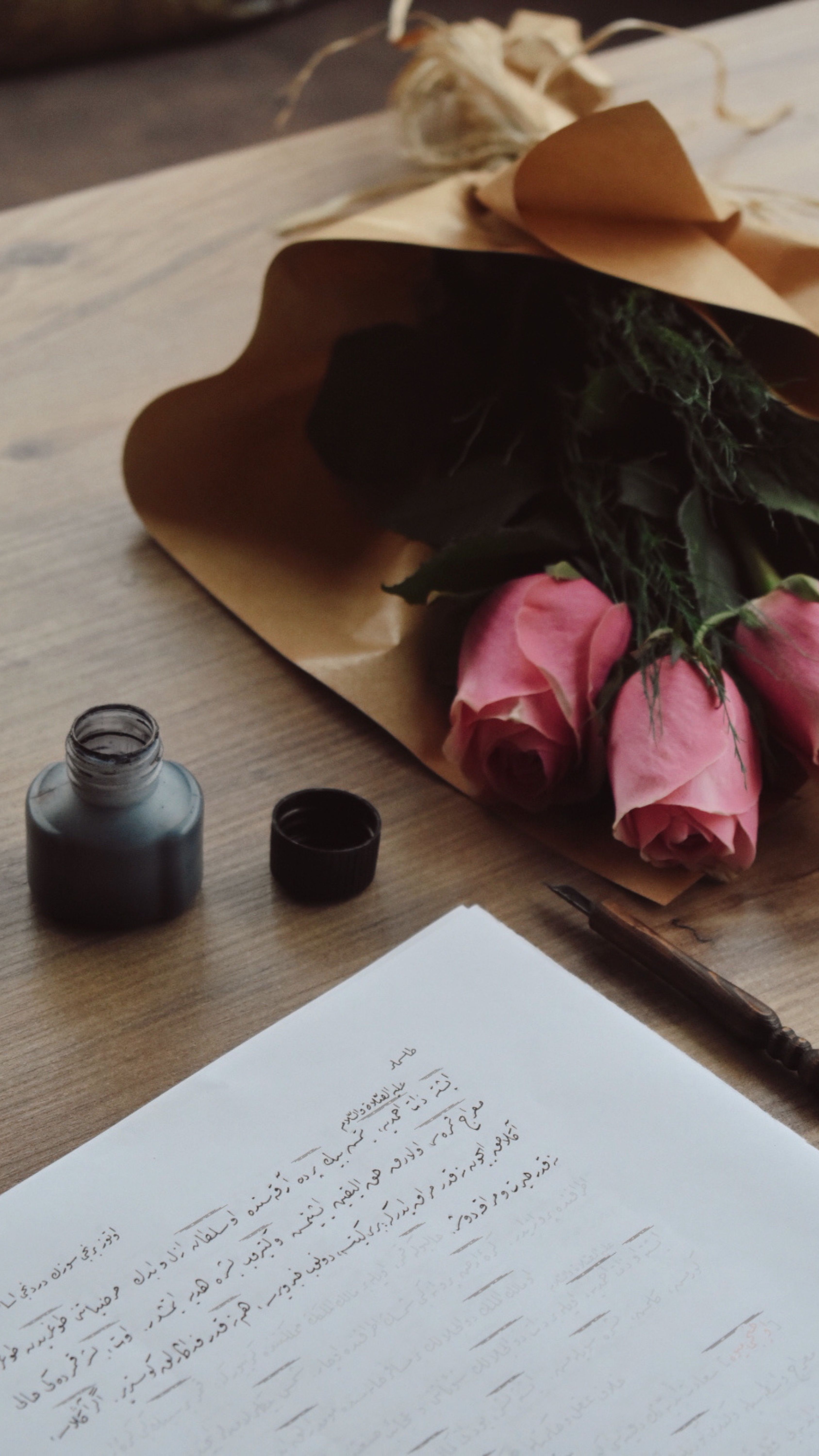 Açık bir defter, dolma kalem ve kurutulmuş güller